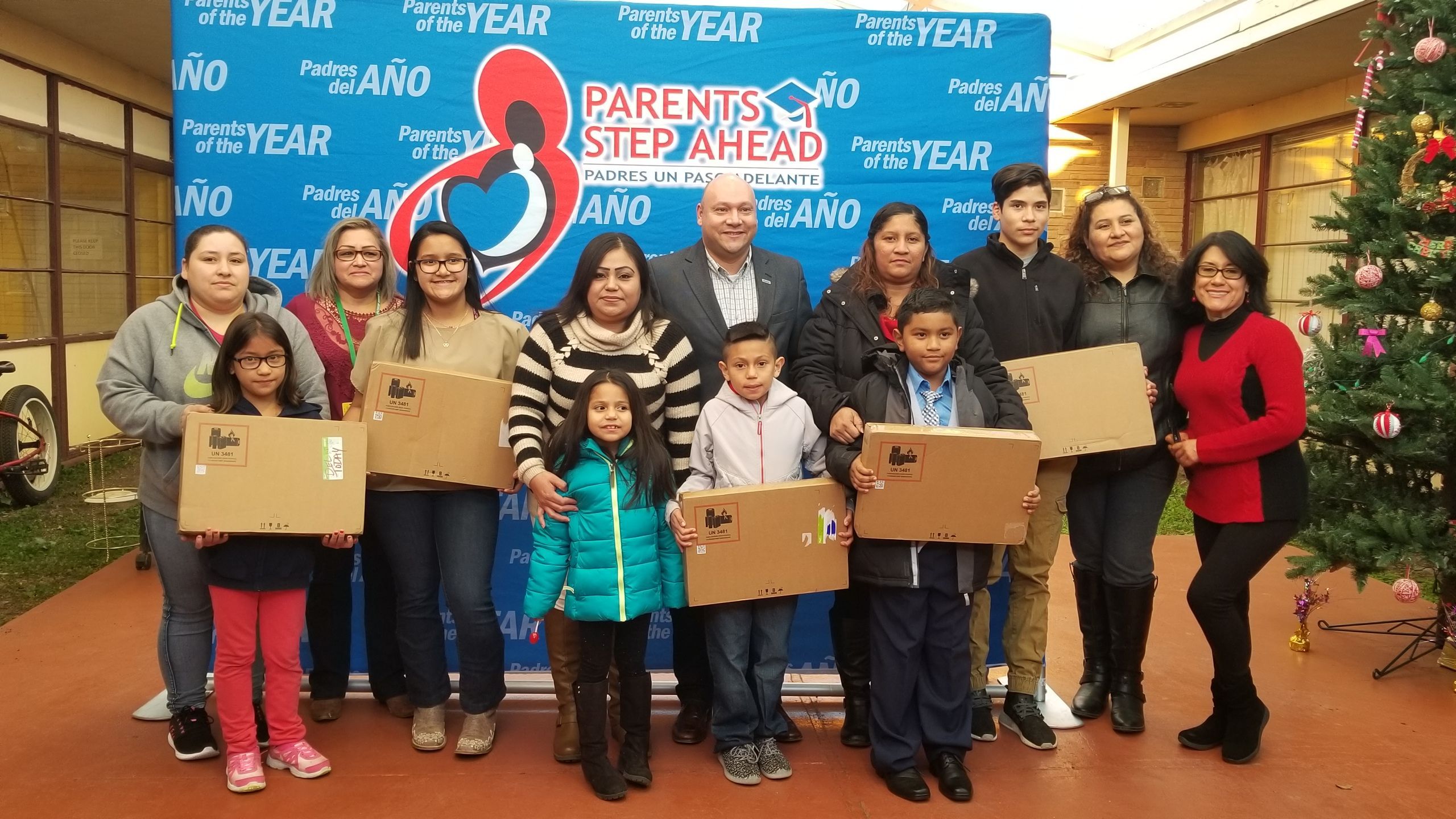Jesse Cortez, Global Inclusion Effectiveness Lead at HPE celebrates with "Parents of the Year" and rewards students by donating laptops.