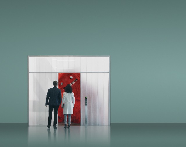 Man and woman looking through doorway at I.T. monster