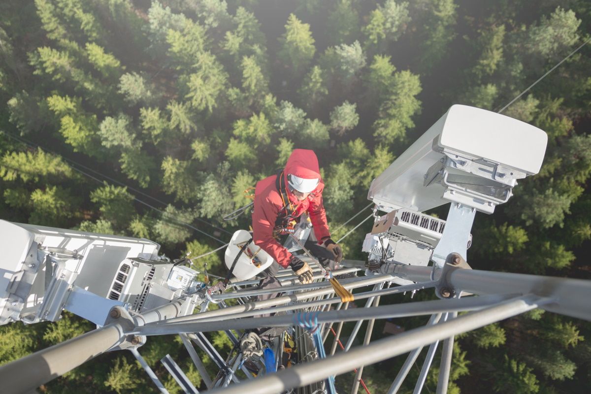 Engineer climbing a 5G Open RAN cellular tower