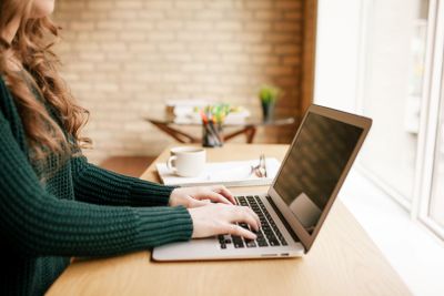 stock-photo-young-woman-using-laptop-at-desk-138378411.jpg
